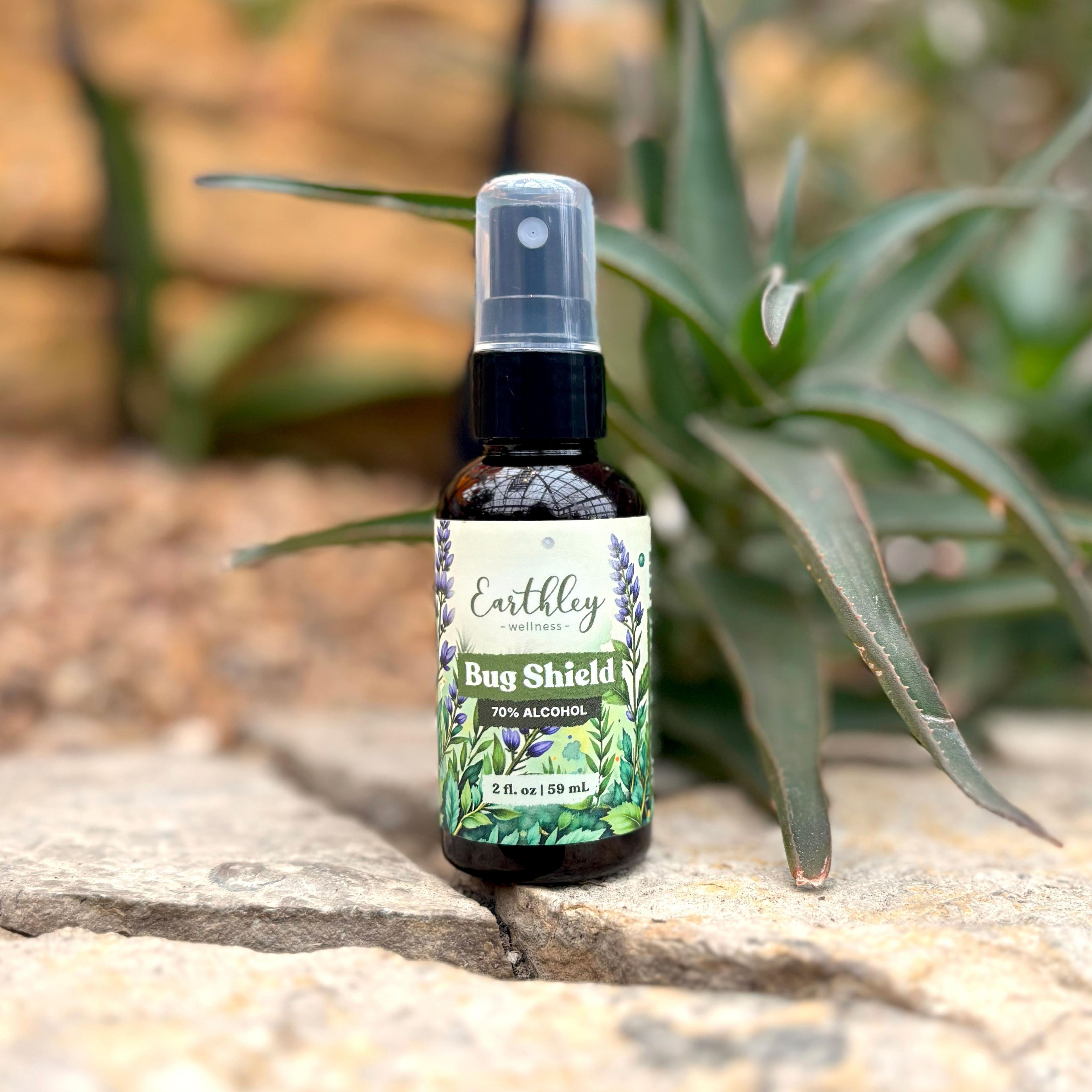Earthley Bug Shield natural insect repellent spray bottle with botanical label on stone surface with aloe plant