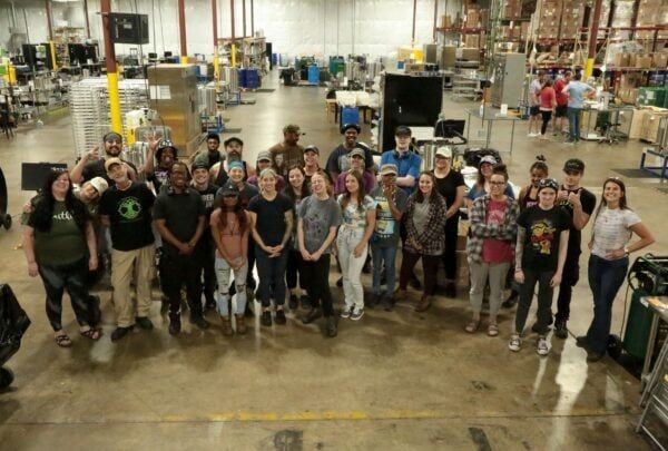 Earthley production team featuring approximately 30 employees gathered in warehouse facility