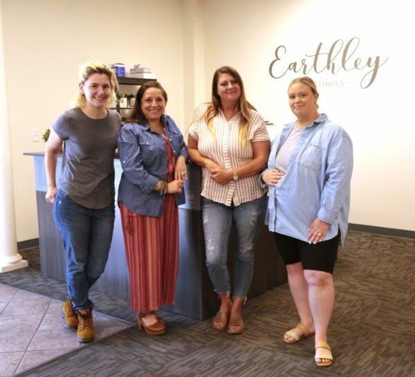 Earthley Yearbook 2023 Customer Service Team group photo showing employees smiling together in office setting with cream walls