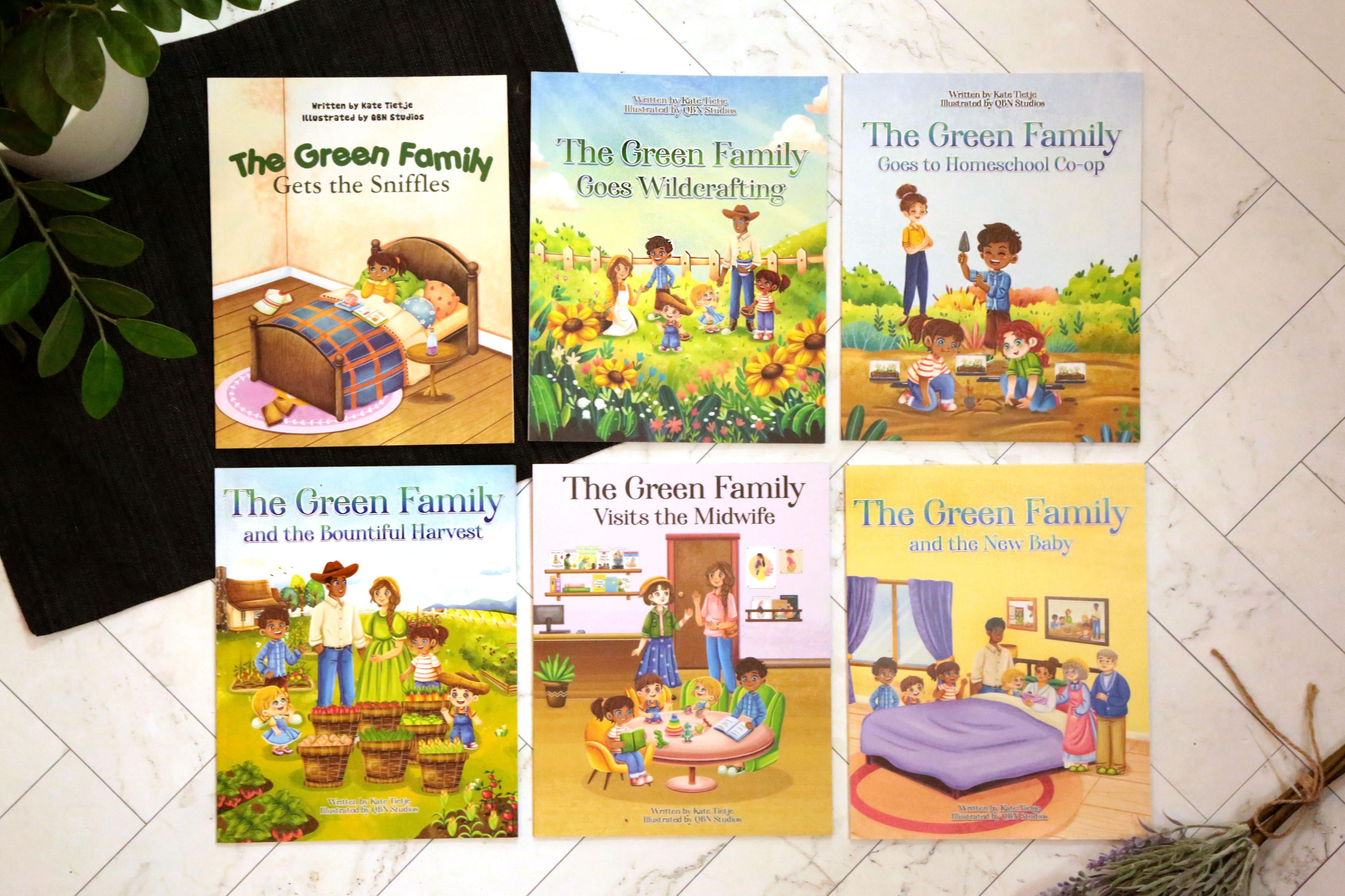 Collection of six Green Family children's books displayed on white surface showing Gets the Sniffles, Goes Wildcrafting, Goes to Homeschool Co-op, Bountiful Harvest, Visits the Midwife, and New Baby titles