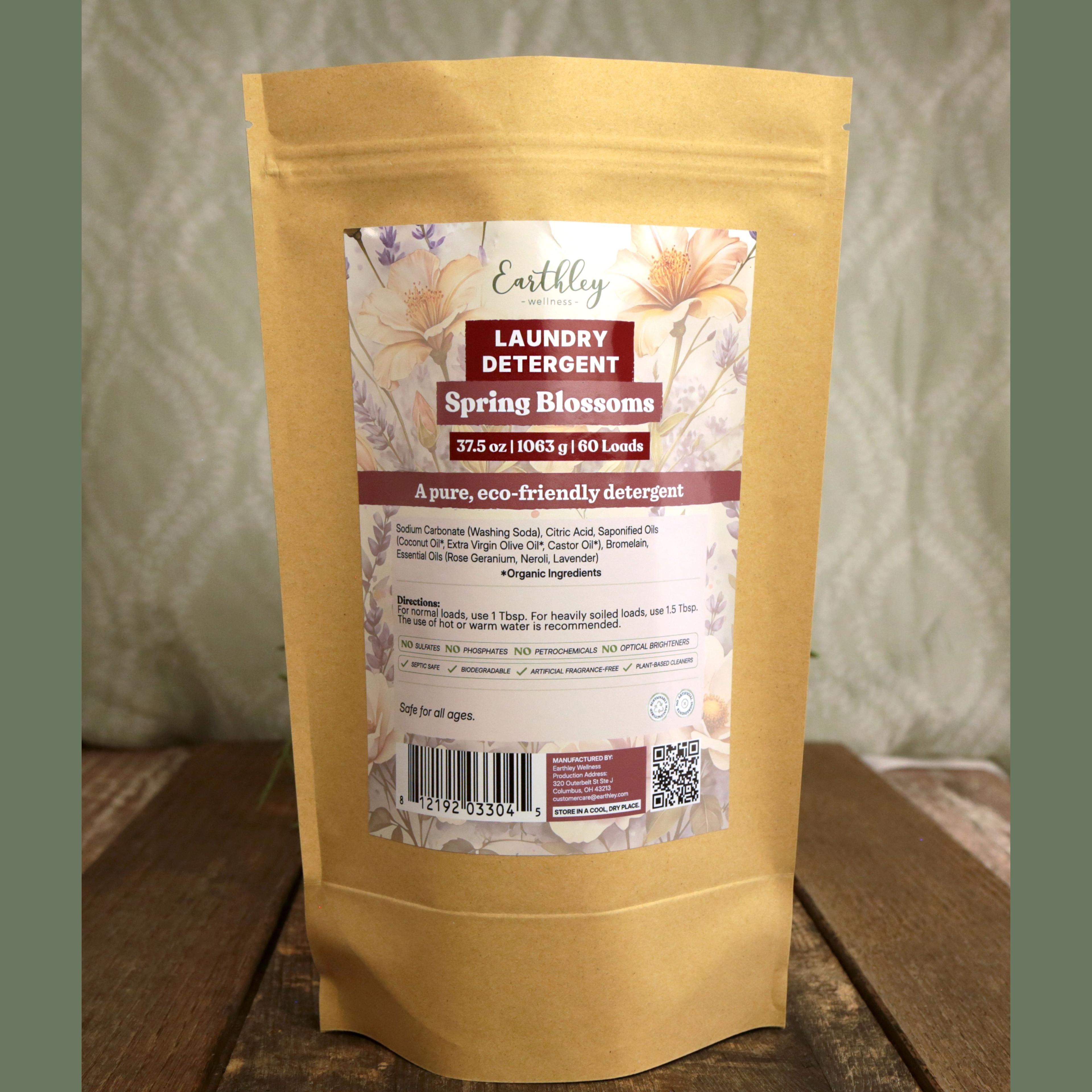 Earthley Laundry Detergent Spring Blossoms 37.5 oz kraft stand-up pouch with floral label featuring pink and peach flowers, 60 loads, eco-friendly formula, on wooden surface