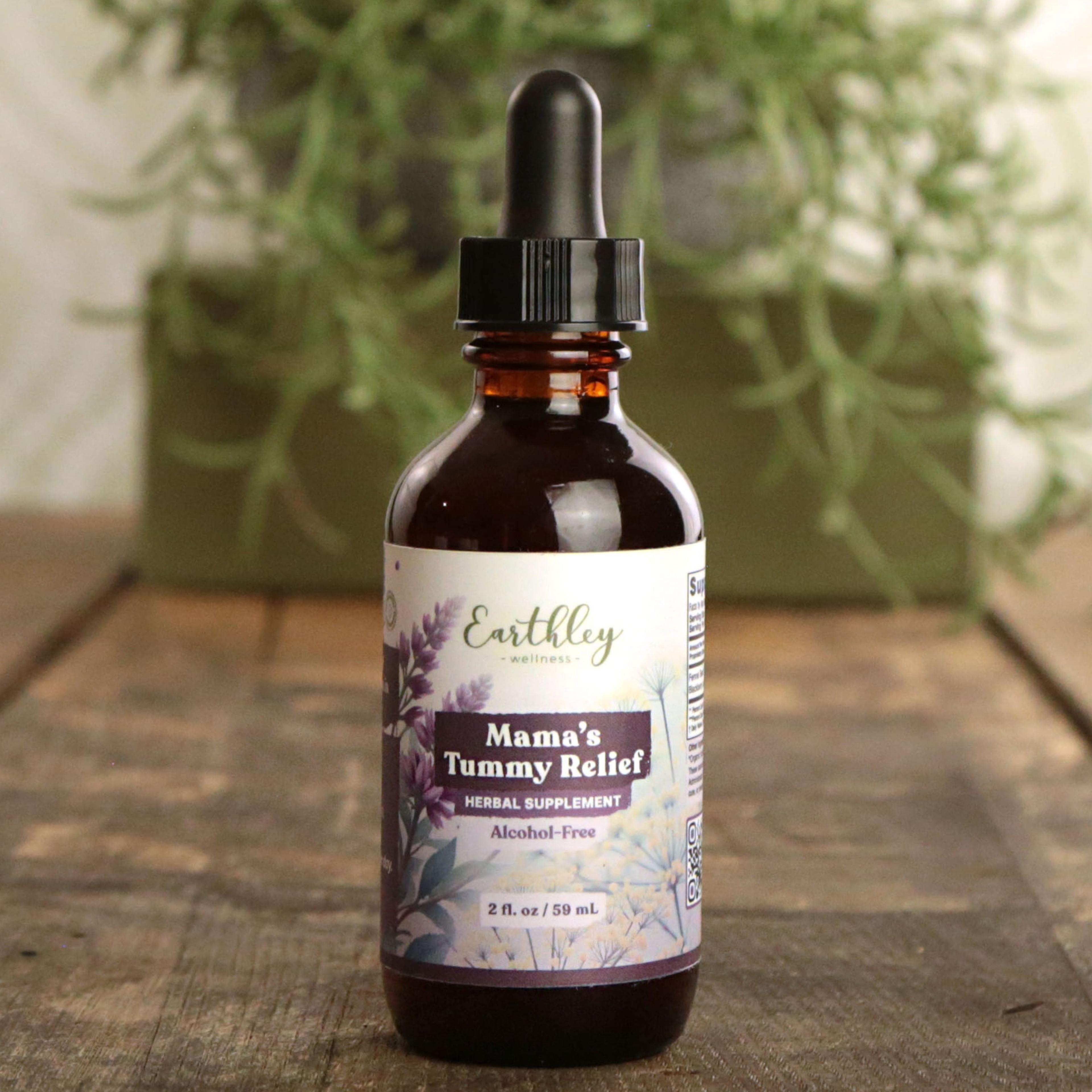 Earthley Mamas Tummy Relief 2oz amber dropper bottle with soft pink floral label for digestive support during pregnancy on rustic wood