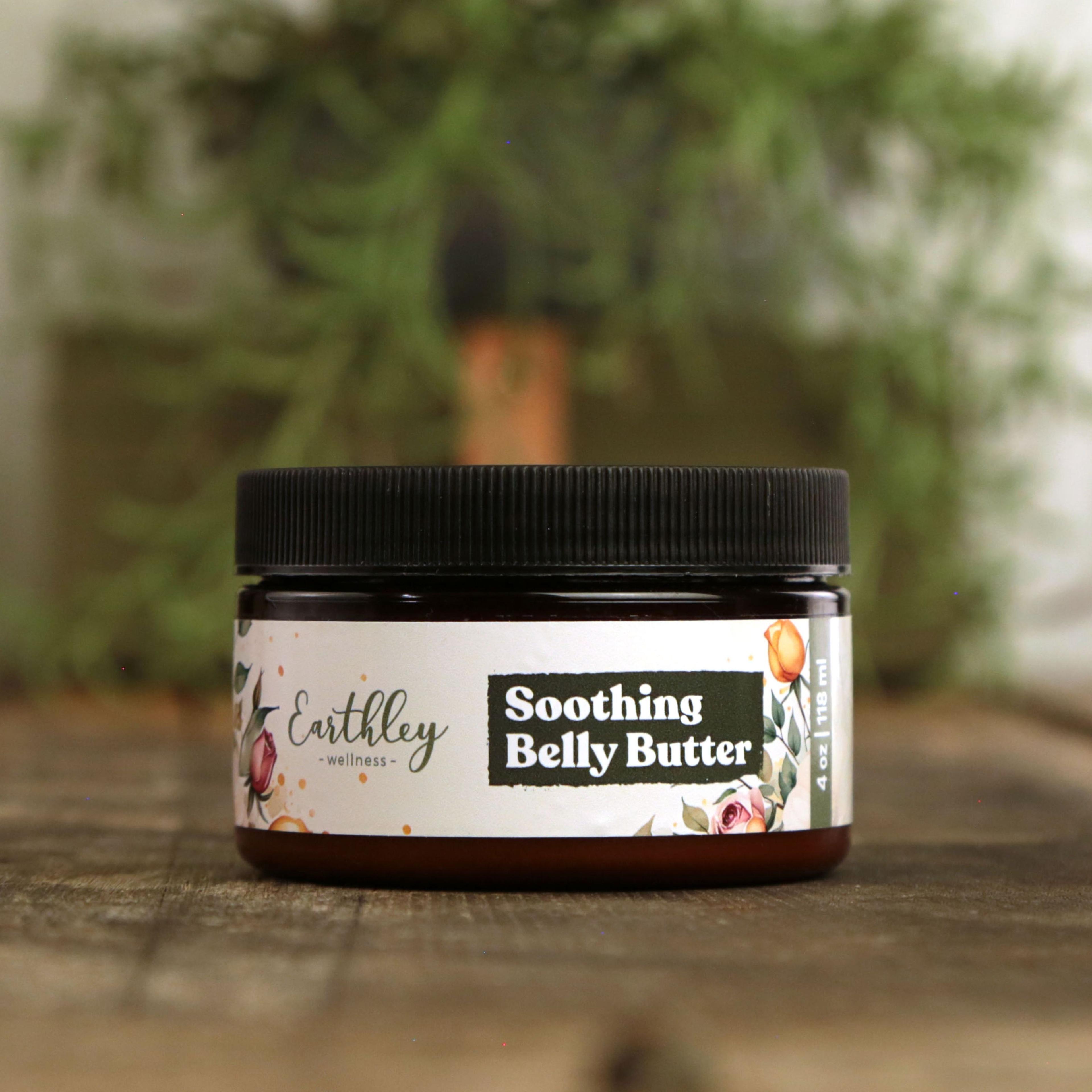 Earthley Soothing Belly Butter 4 oz amber glass jar with black lid featuring soft floral watercolor label with roses and orange tulips on wooden surface with greenery