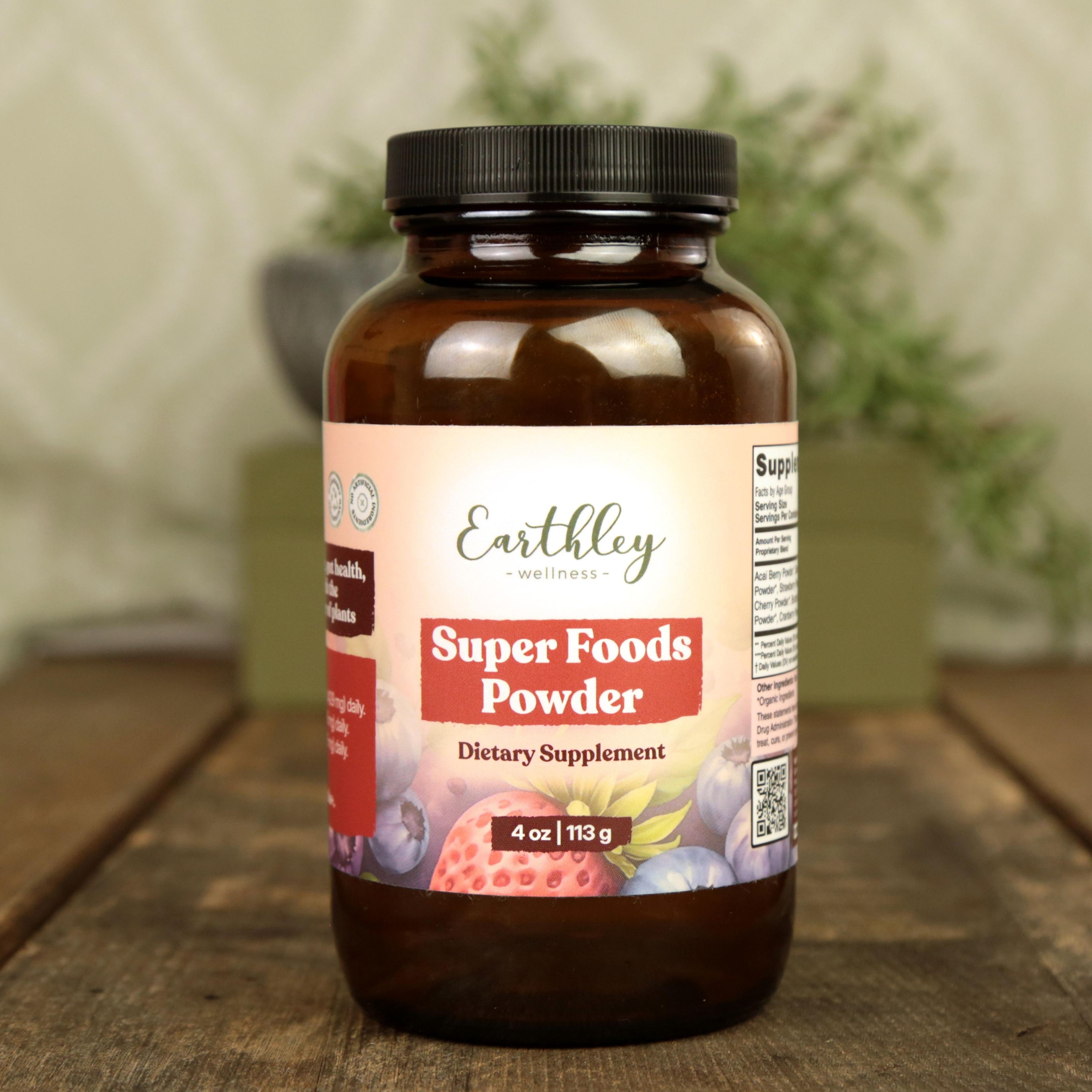 Earthley Super Foods Powder 4 oz in amber glass jar with black lid featuring colorful label with strawberries, blueberries, and superfood imagery on wooden surface