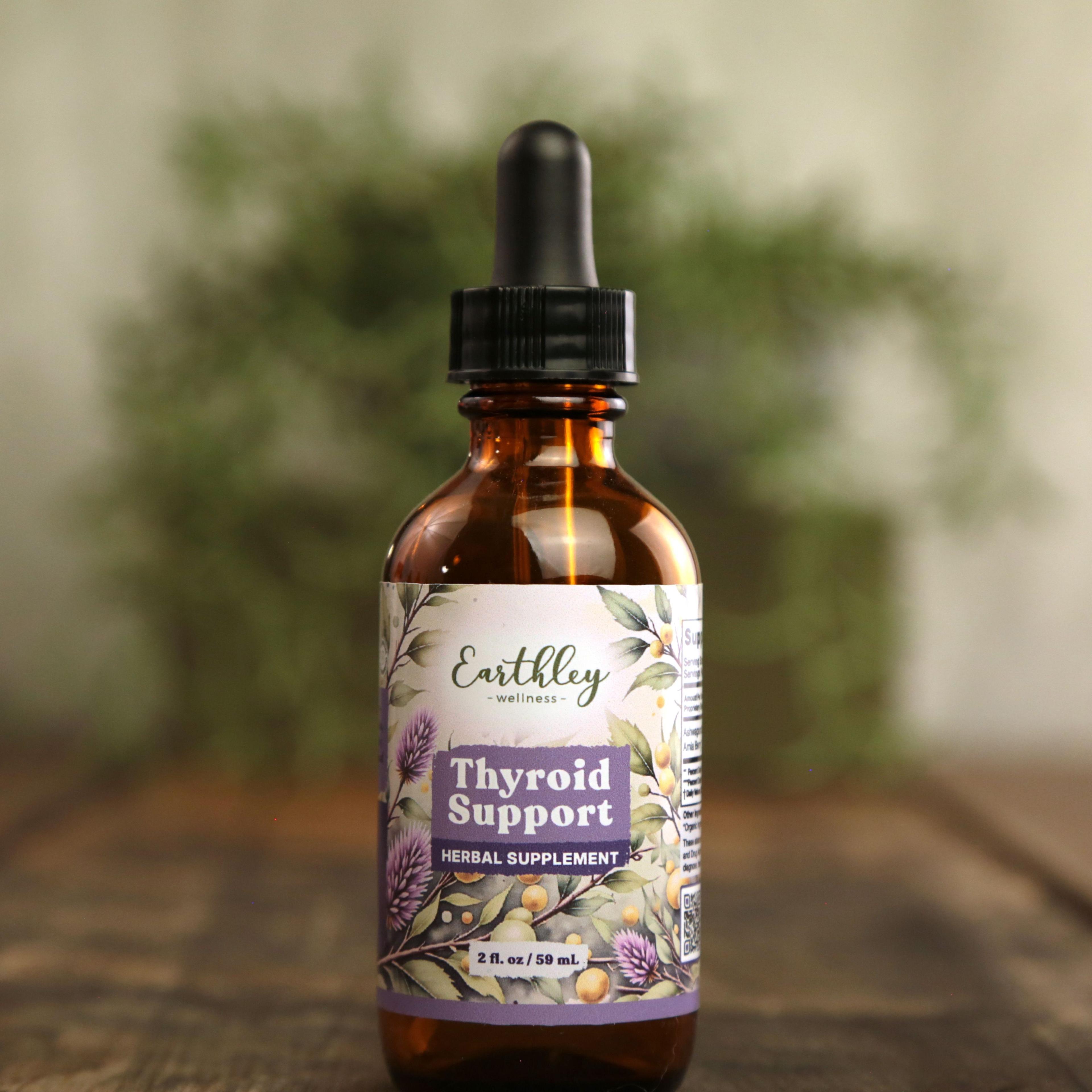 Earthley Thyroid Support 2 oz amber dropper bottle with botanical label on wooden surface
