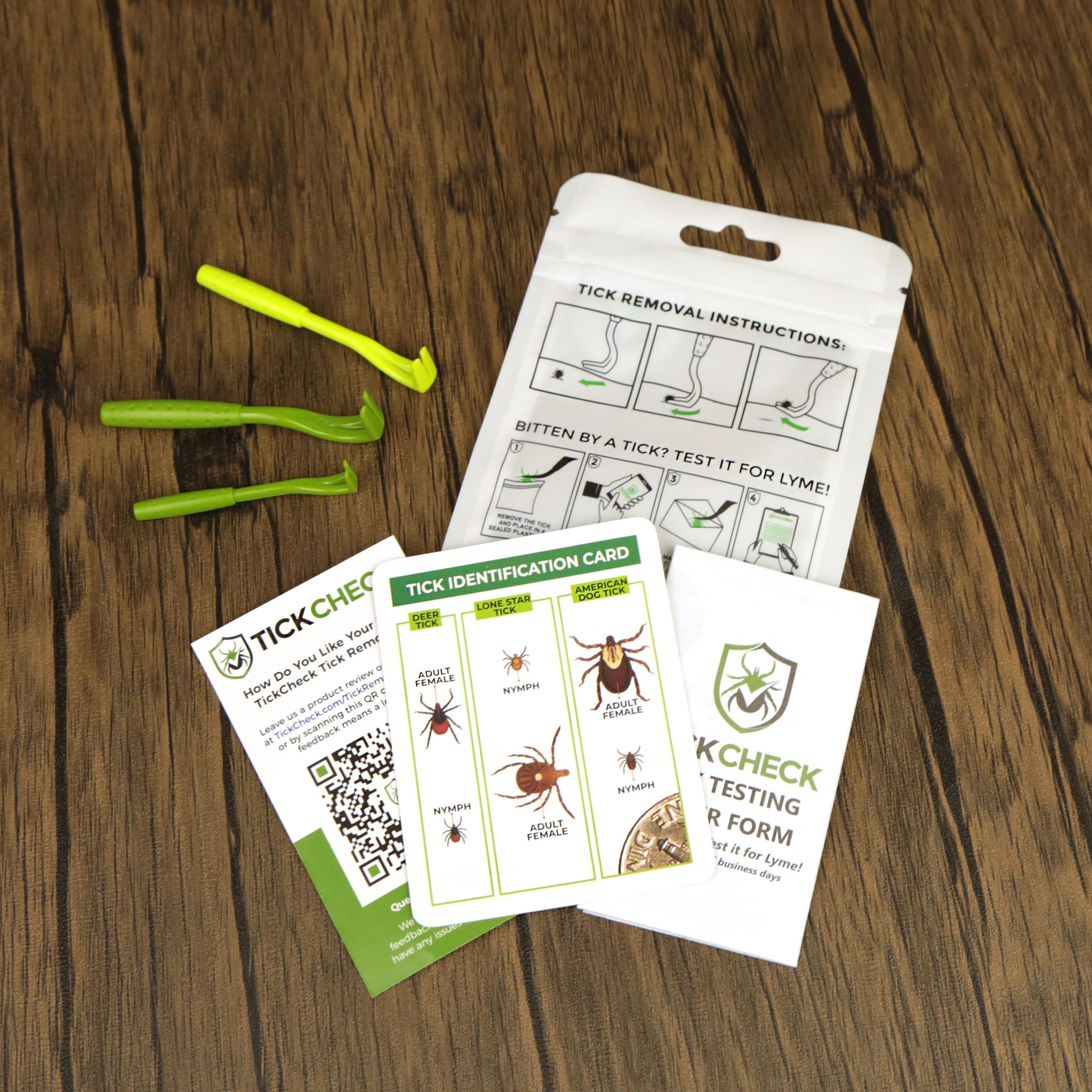 Tick removal kit with green tweezers, instruction cards, and identification guide on wooden surface