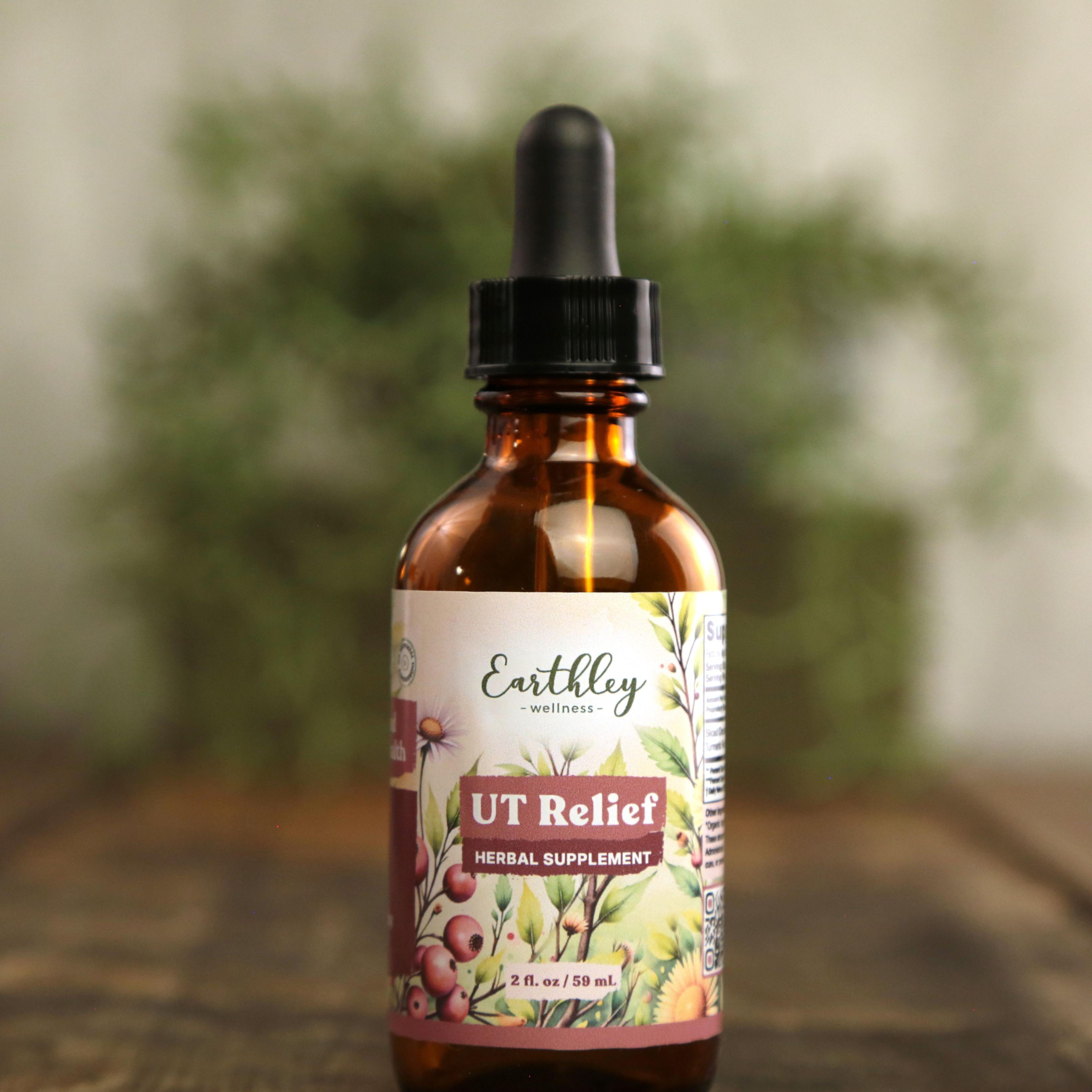 Earthley UT Relief 2 oz amber dropper bottle with floral botanical label featuring cranberries and echinacea flowers, labeled as Herbal Supplement, on wooden surface with greenery