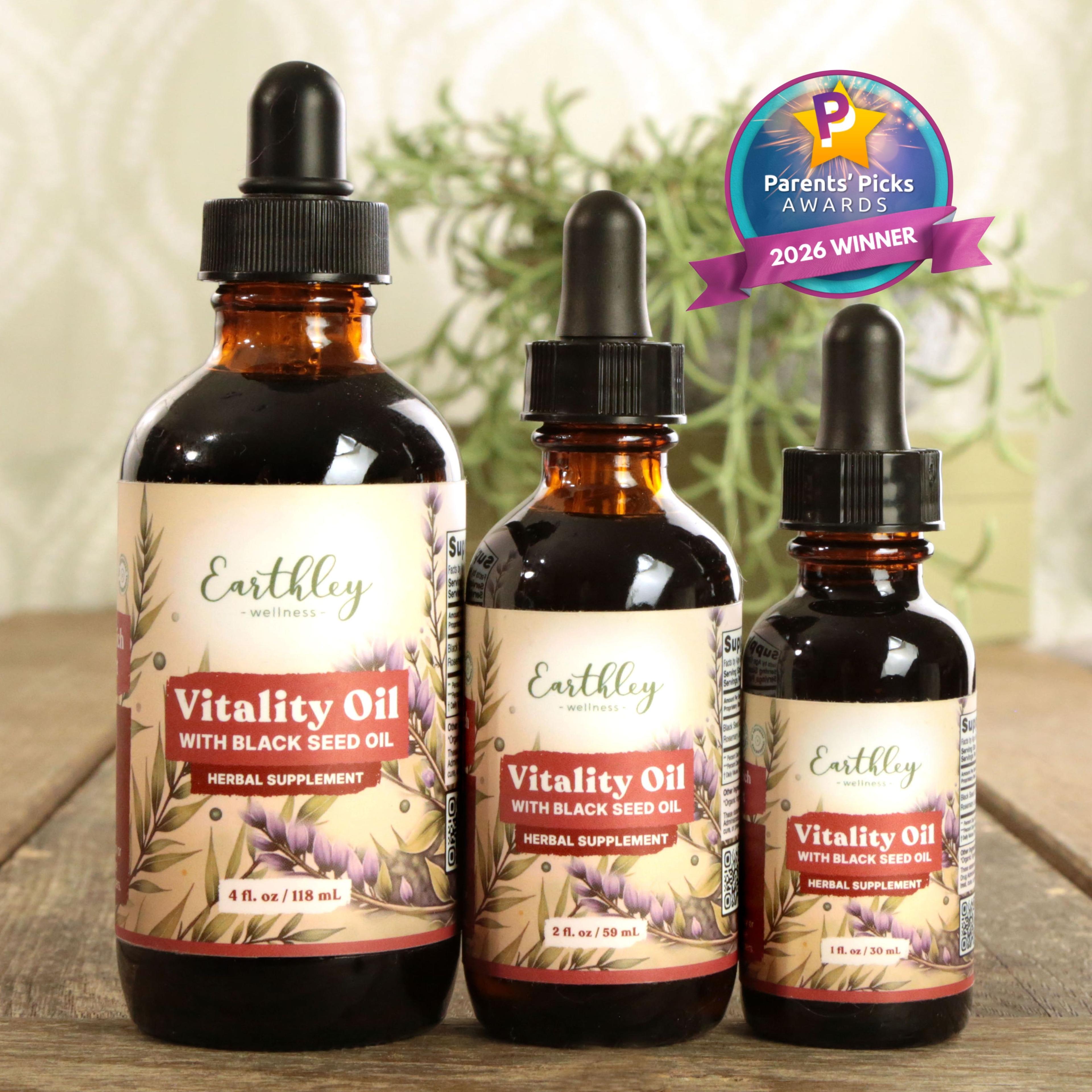 Three amber glass bottles of Earthley Vitality Oil with Black Seed Oil in different sizes, featuring Parents' Picks 2026 Winner award badge
