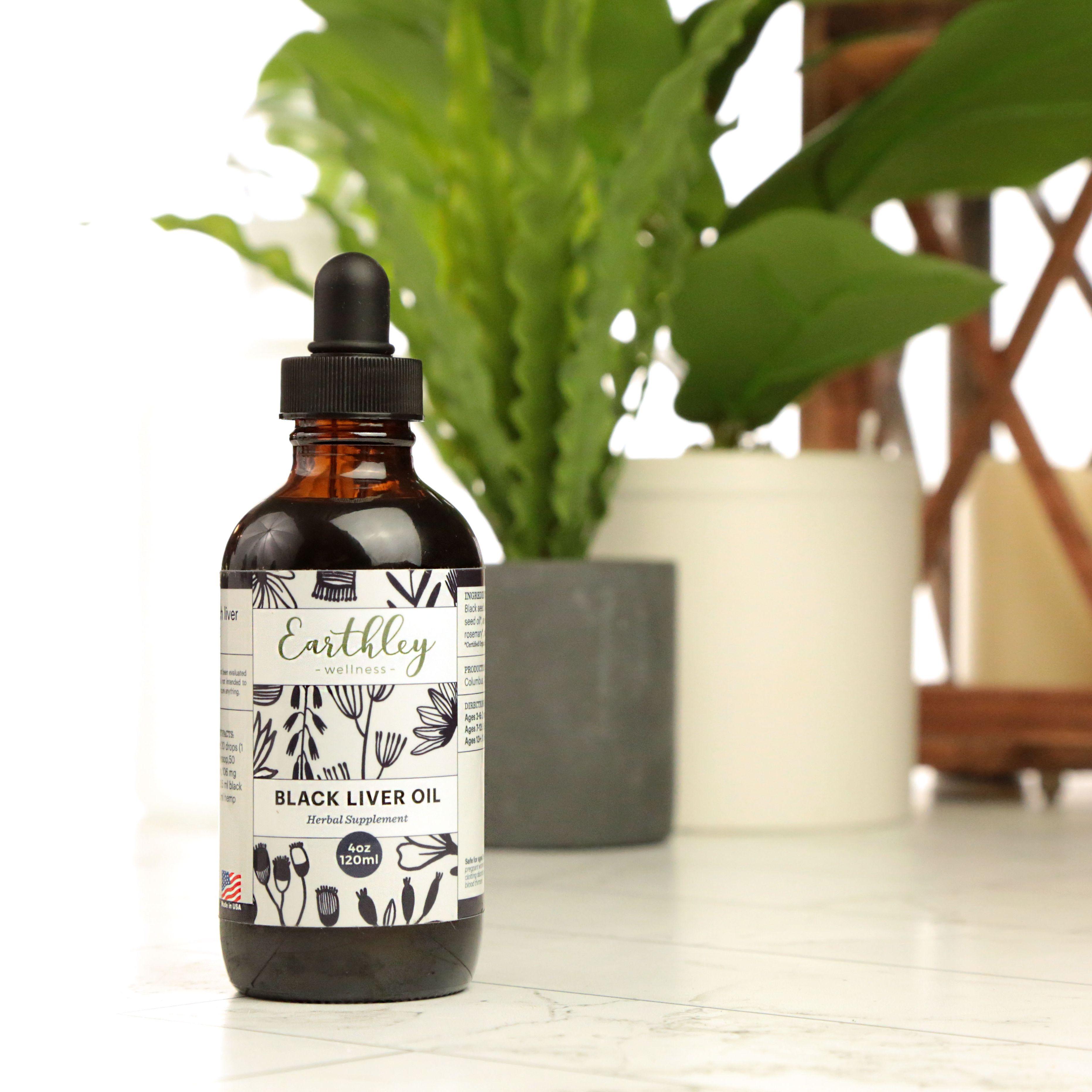 Earthley Black Liver Oil 4oz amber dropper bottle with black botanical label design, displayed with green plants in background