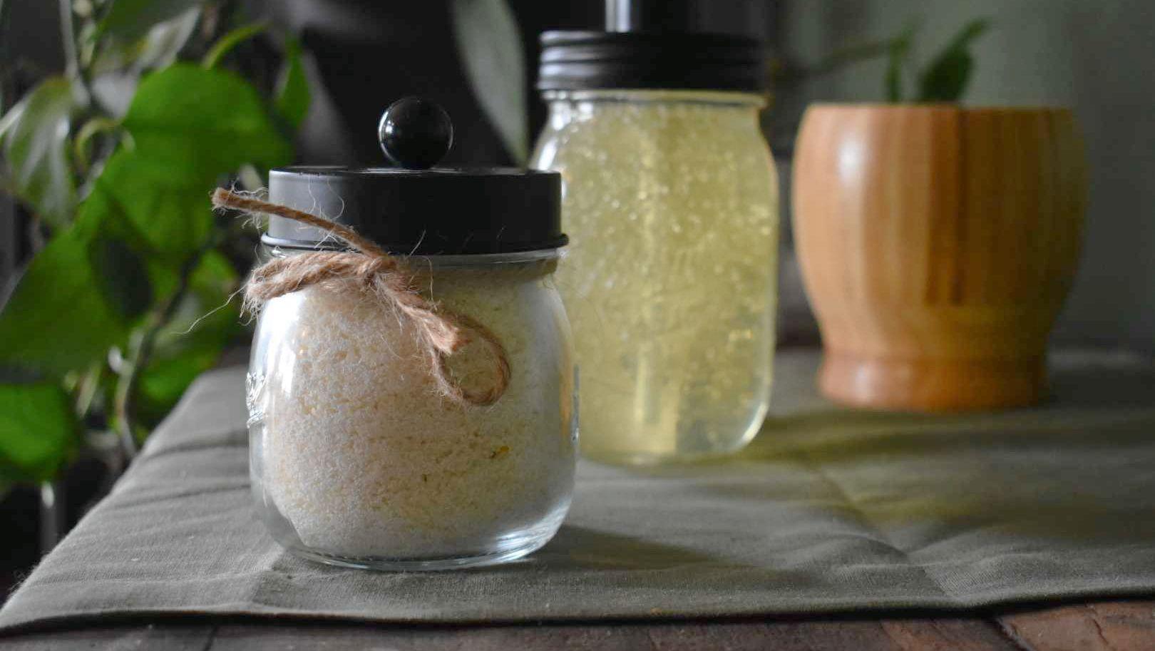 Glass jar with herbal powder tied with twine, surrounded by natural wellness ingredients and green plants