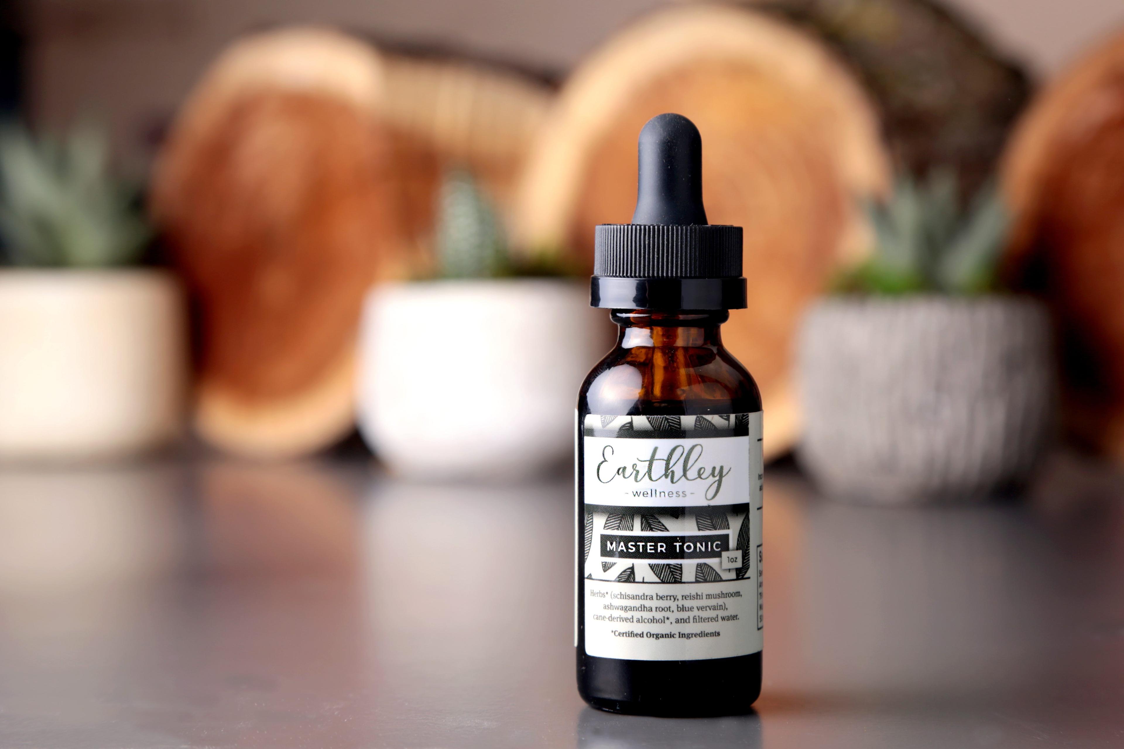Earthley How Tension Relief Roller Works infographic with sage green background showing amber rollerball bottle with ingredient photos of essential oils for headache and tension relief on circular images