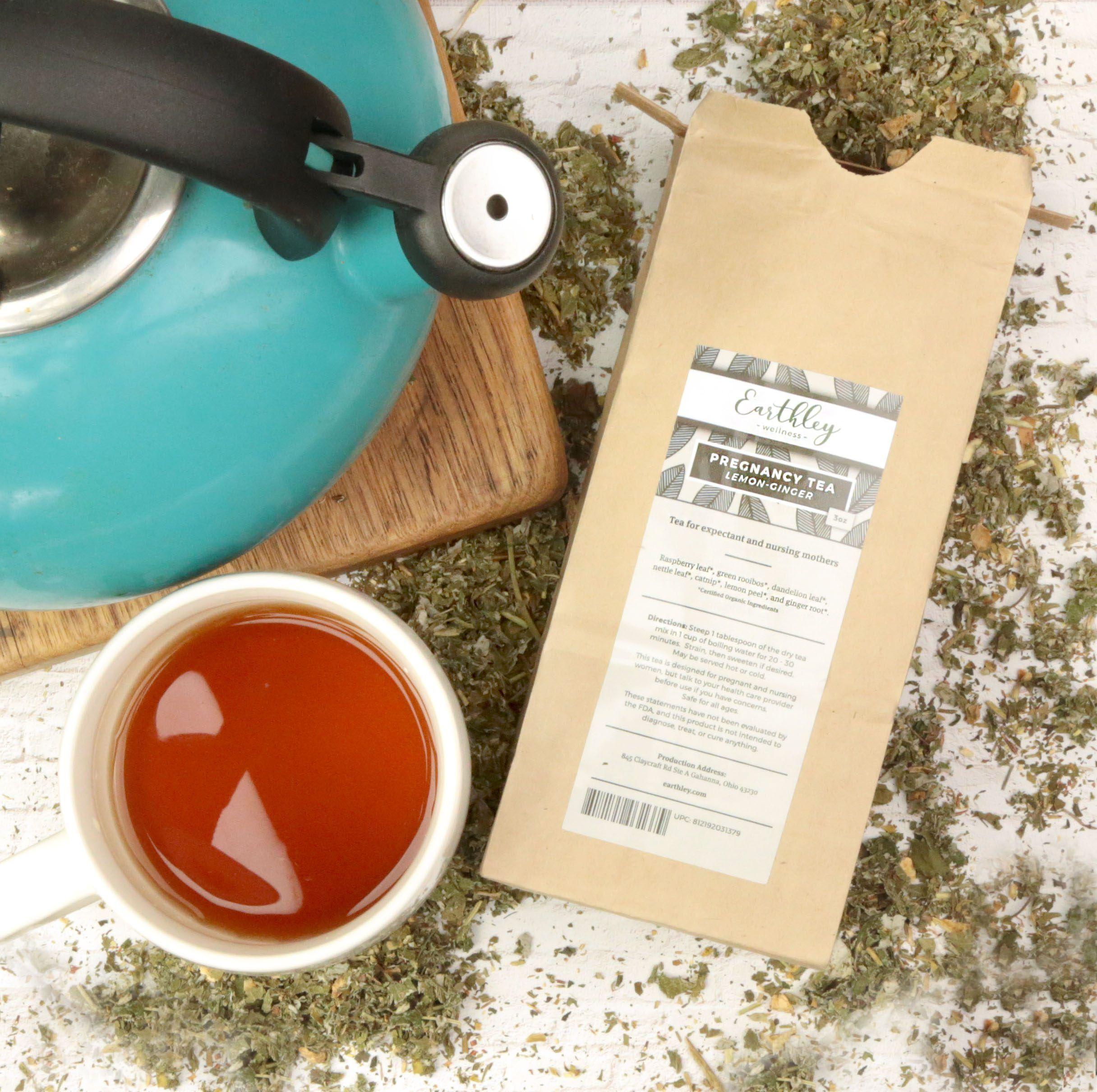 Pregnancy Tea in Lemon-Ginger flavor in kraft bag with gray label, teal teapot, brewed cup of tea, and loose herbs