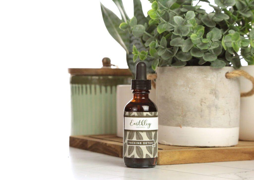 Vaccine Detox herbal extract in amber dropper bottle with green leaf label and plants